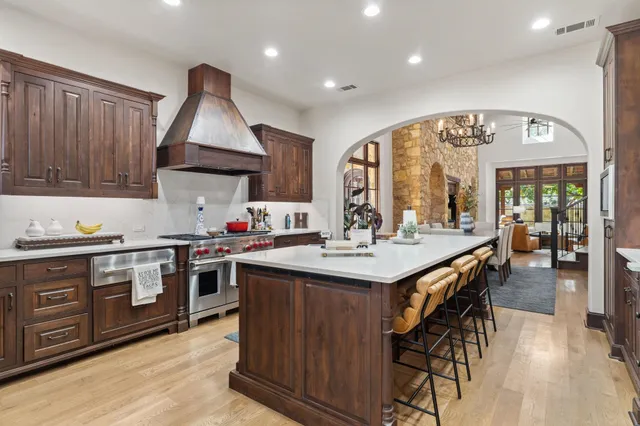 a kitchen with stainless steel appliances granite countertop a stove and a wooden floors