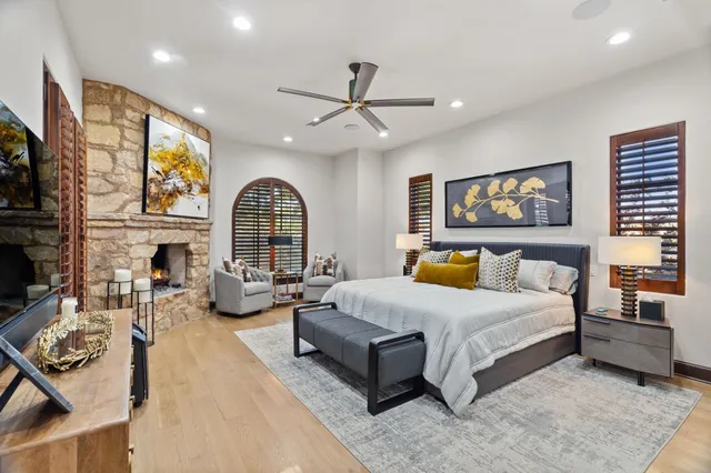 a spacious bedroom with a bed a couch and a large window