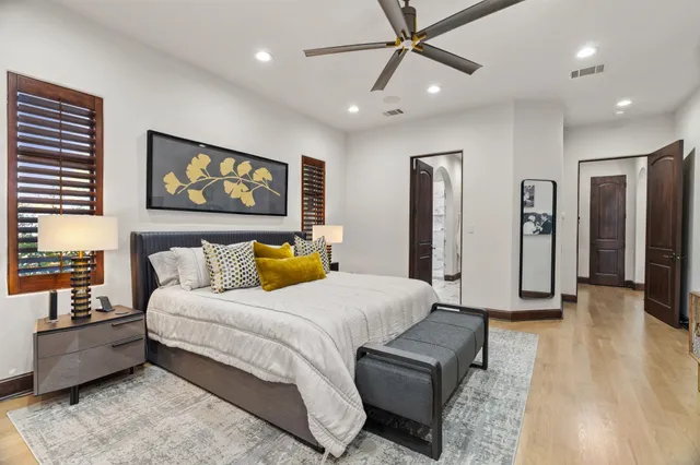 a spacious bedroom with a bed a couch and a chandelier