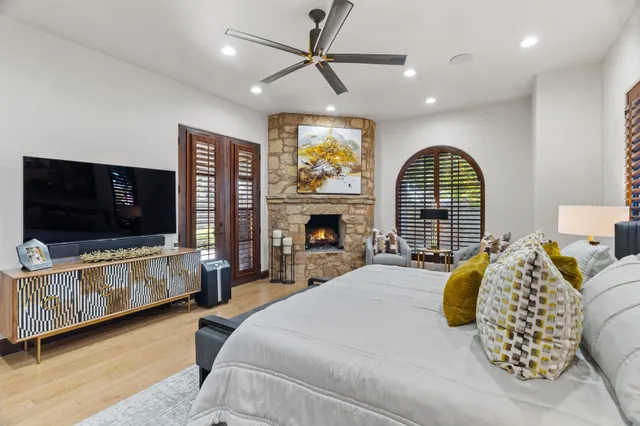 a spacious bedroom with a bed and a flat screen tv