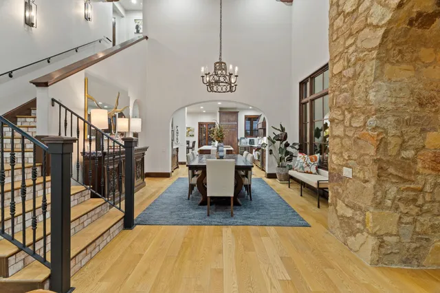 a view of a livingroom with furniture wooden floor windows and a chandelier