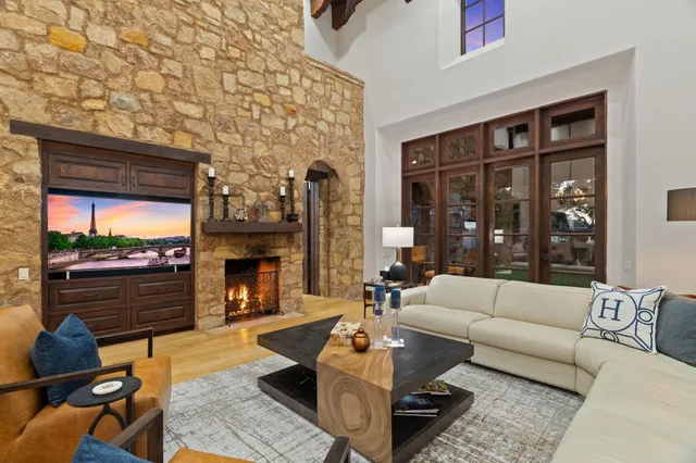 a living room with furniture a fireplace and a floor to ceiling window