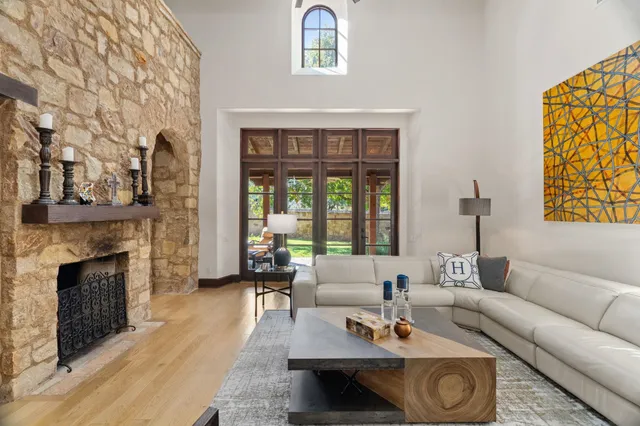 a living room with furniture a fireplace and a floor to ceiling window