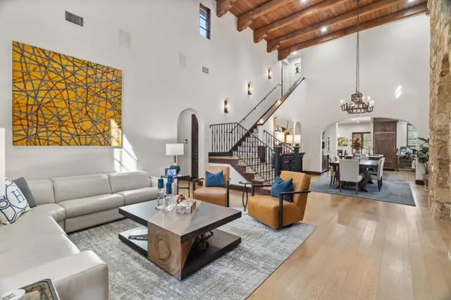 a living room with furniture kitchen view and a large window