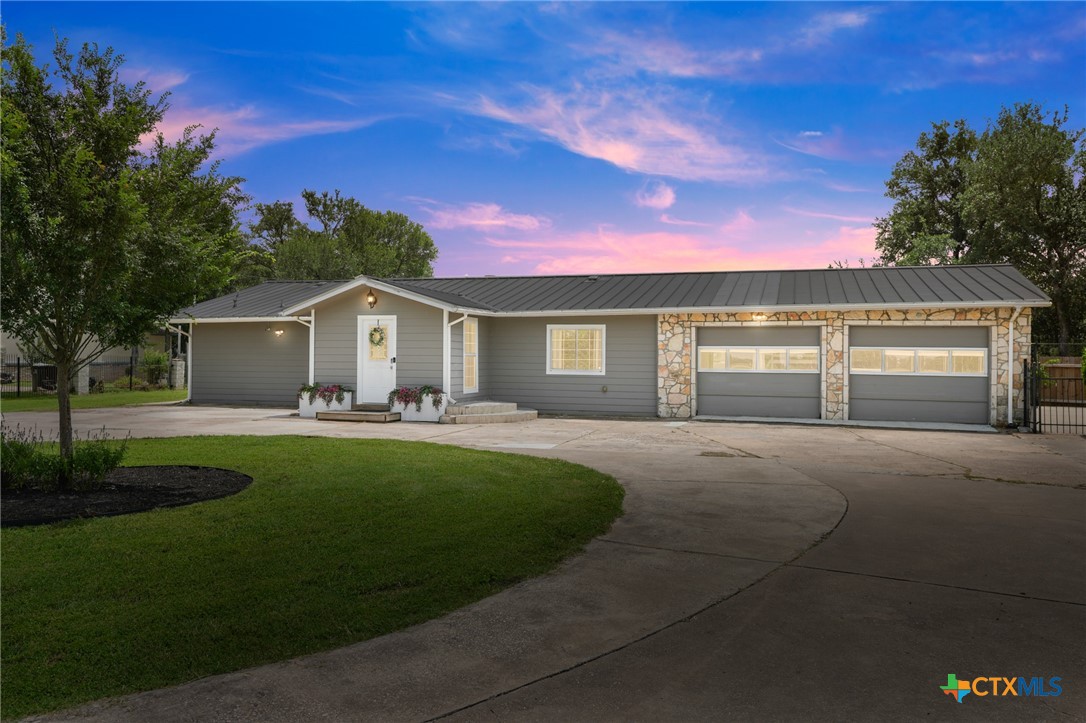 9725 Bock Road Buda, TX 78610 - Photo 1 of 37 An inviting exterior with a manicured lawn and attached garage.