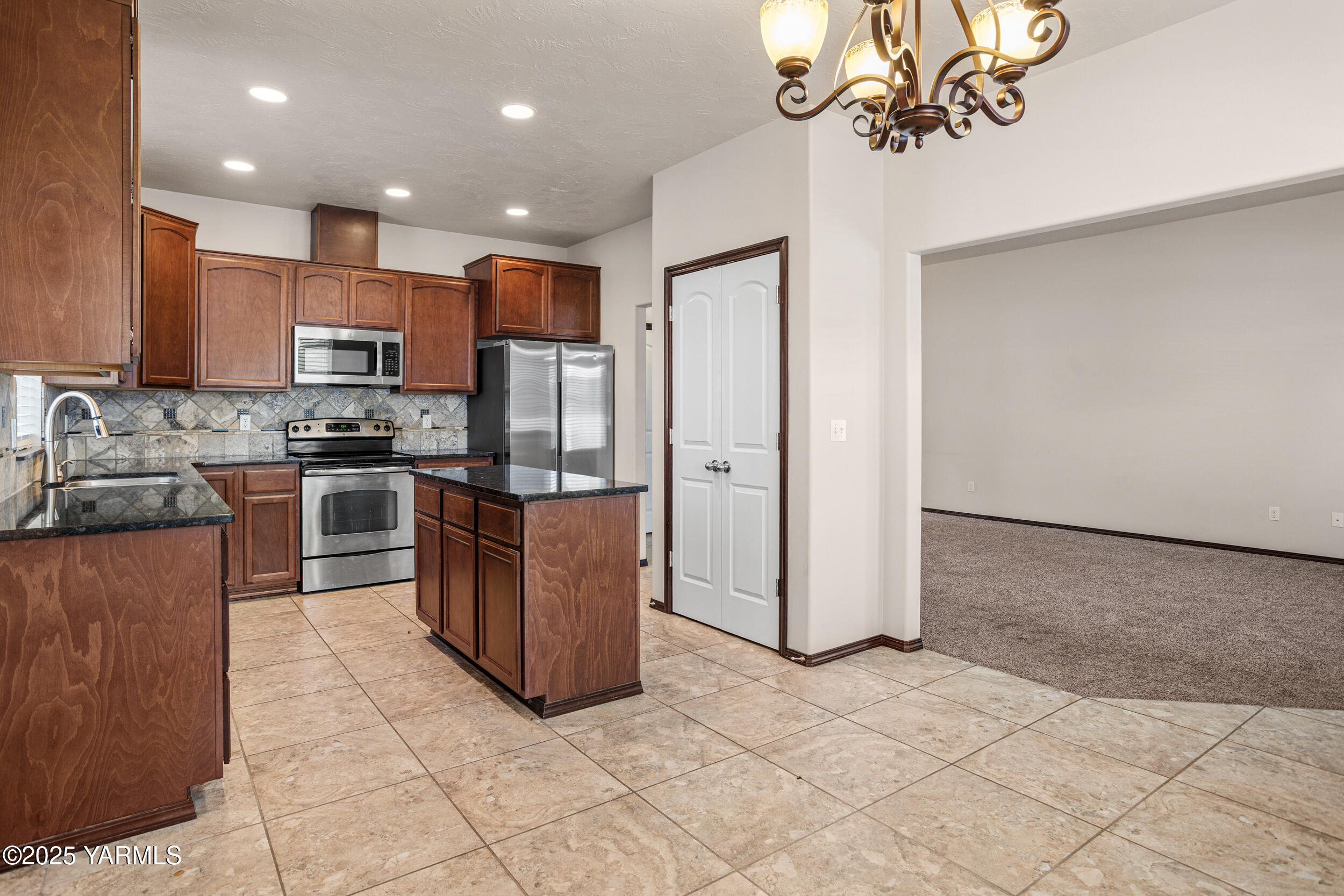 2017 South 59th Avenue Yakima, WA 98903 - Photo 11 of 32 a kitchen with stainless steel appliances granite countertop a stove a refrigerator a sink a microwave and island