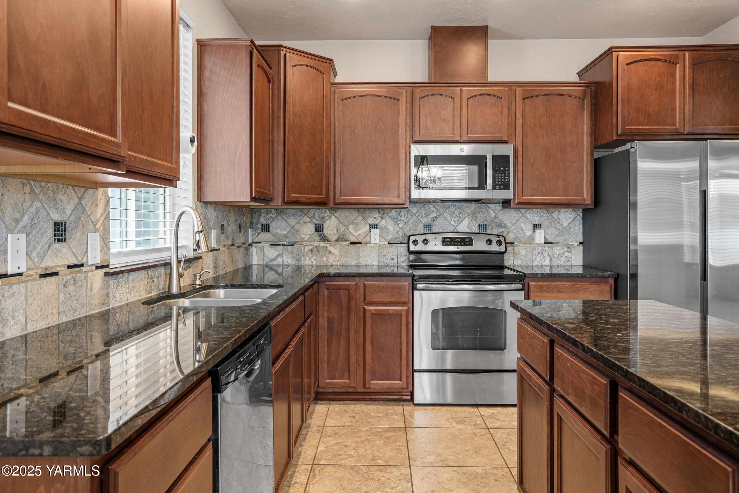 2017 South 59th Avenue Yakima, WA 98903 - Photo 13 of 32 a kitchen with a sink a stove and cabinets