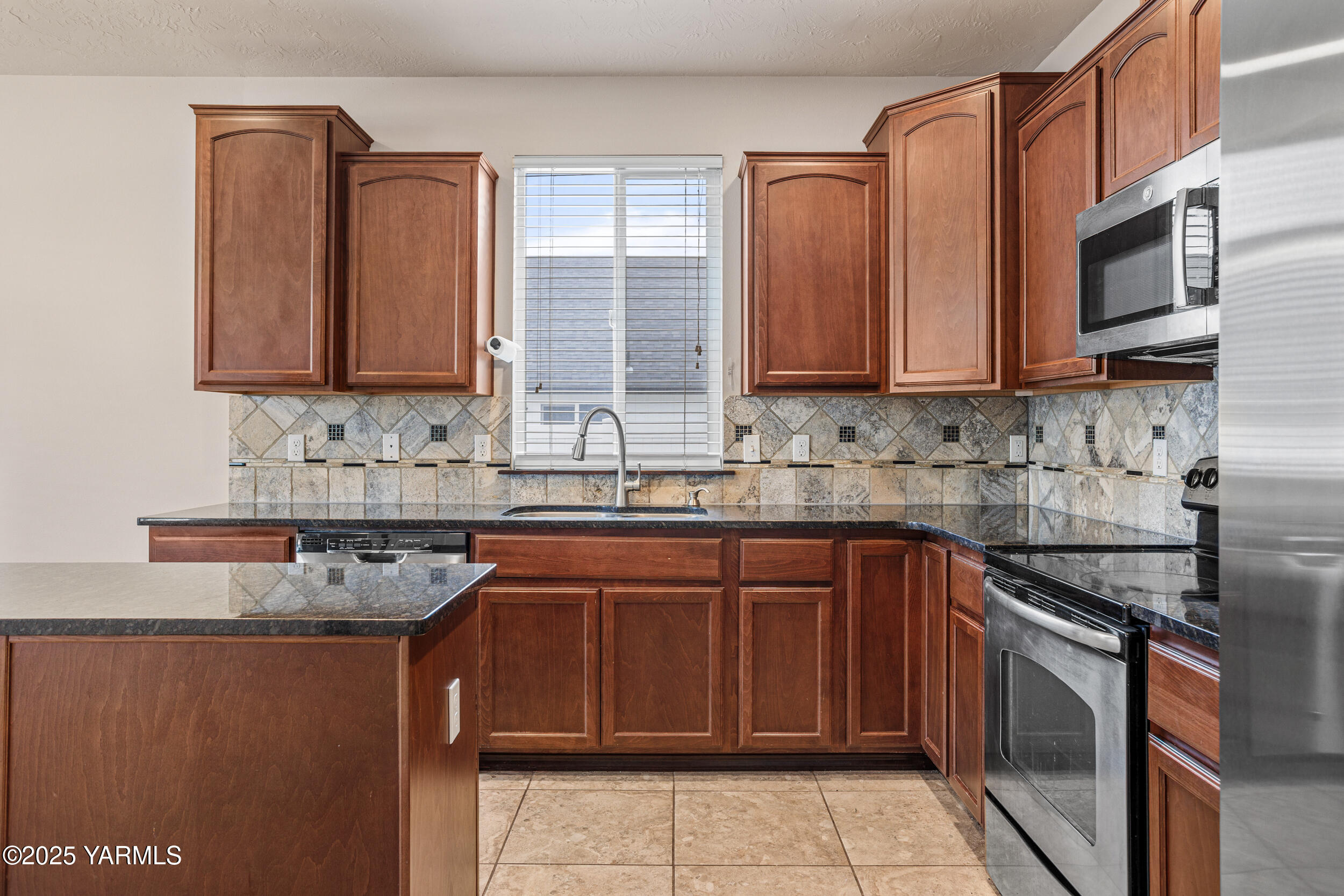 2017 South 59th Avenue Yakima, WA 98903 - Photo 15 of 32 a kitchen with stainless steel appliances granite countertop a sink stove and microwave