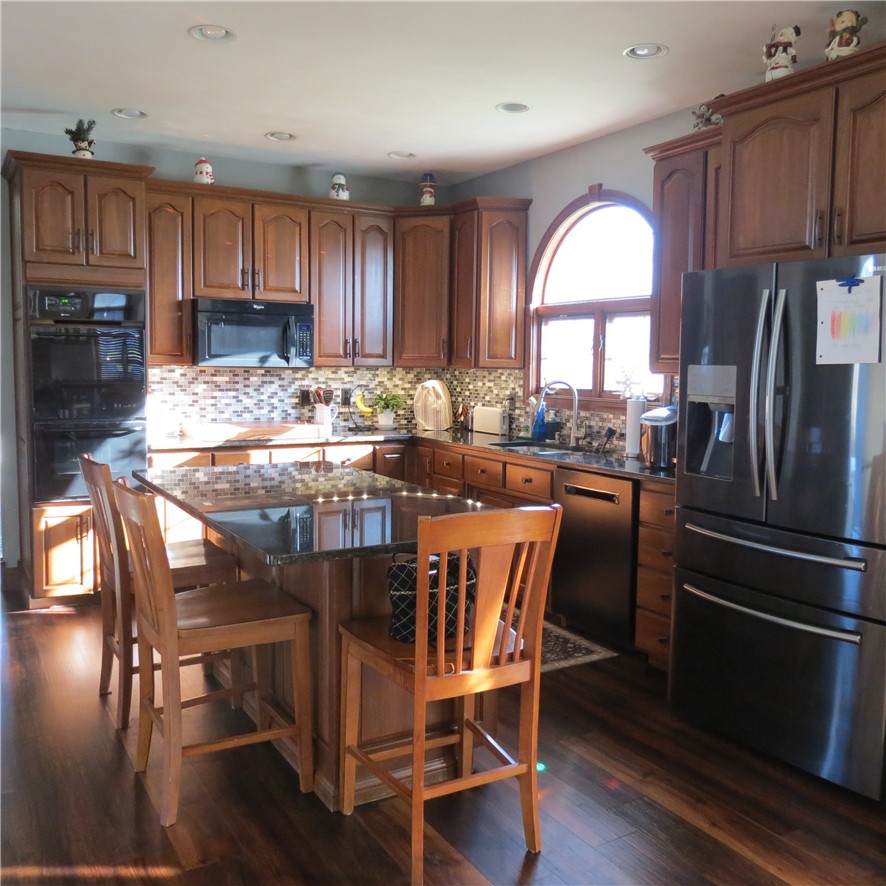 10160 Lochard Road Sidney, OH 45365 - Photo 14 of 41 This spacious kitchen offers ample cabinetry and an expansive island for culinary creativity.