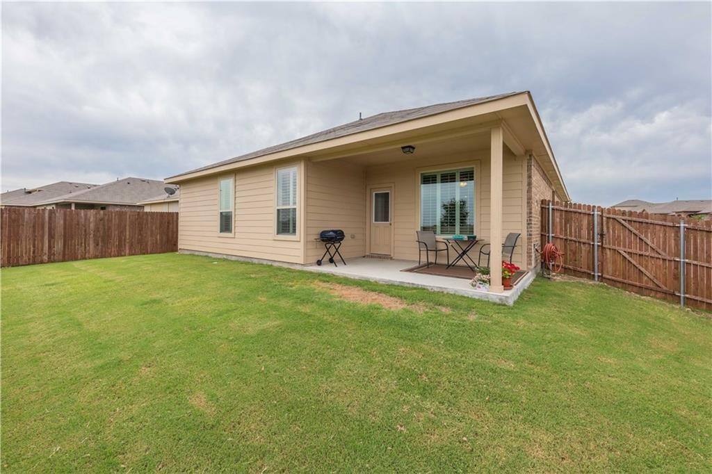 1716 Rio Penasco Road Fort Worth, TX 76052 - Photo 29 of 31 Manicured lawn with a covered concrete patio, privacy fencing, and exterior brick accents
