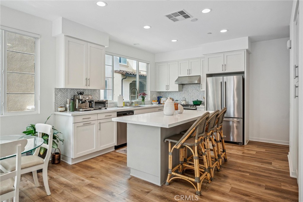 318 Ford Road Costa Mesa, CA 92627 - Photo 7 of 20 a kitchen with a table chairs refrigerator and cabinets
