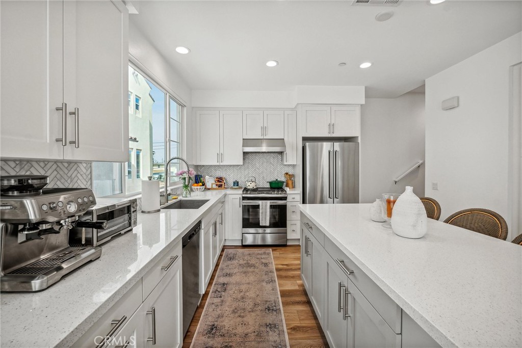 318 Ford Road Costa Mesa, CA 92627 - Photo 9 of 20 a kitchen with kitchen island stainless steel appliances a sink stove and refrigerator