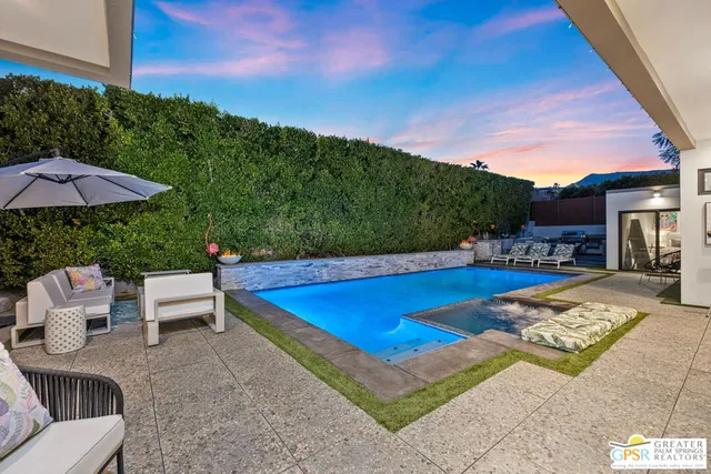 a view of swimming pool with outdoor seating and plants