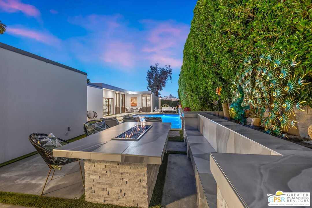 48365 Alan Circle Palm Desert, CA 92260 - Photo 22 of 75 a view of a patio with table and chairs with wooden floor and fence