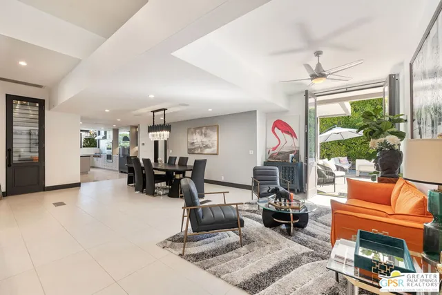 a spacious bedroom with a bed a flat screen tv and chandelier