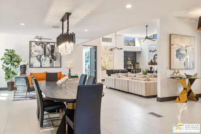 a view of a patio with couches table and chairs and potted plants