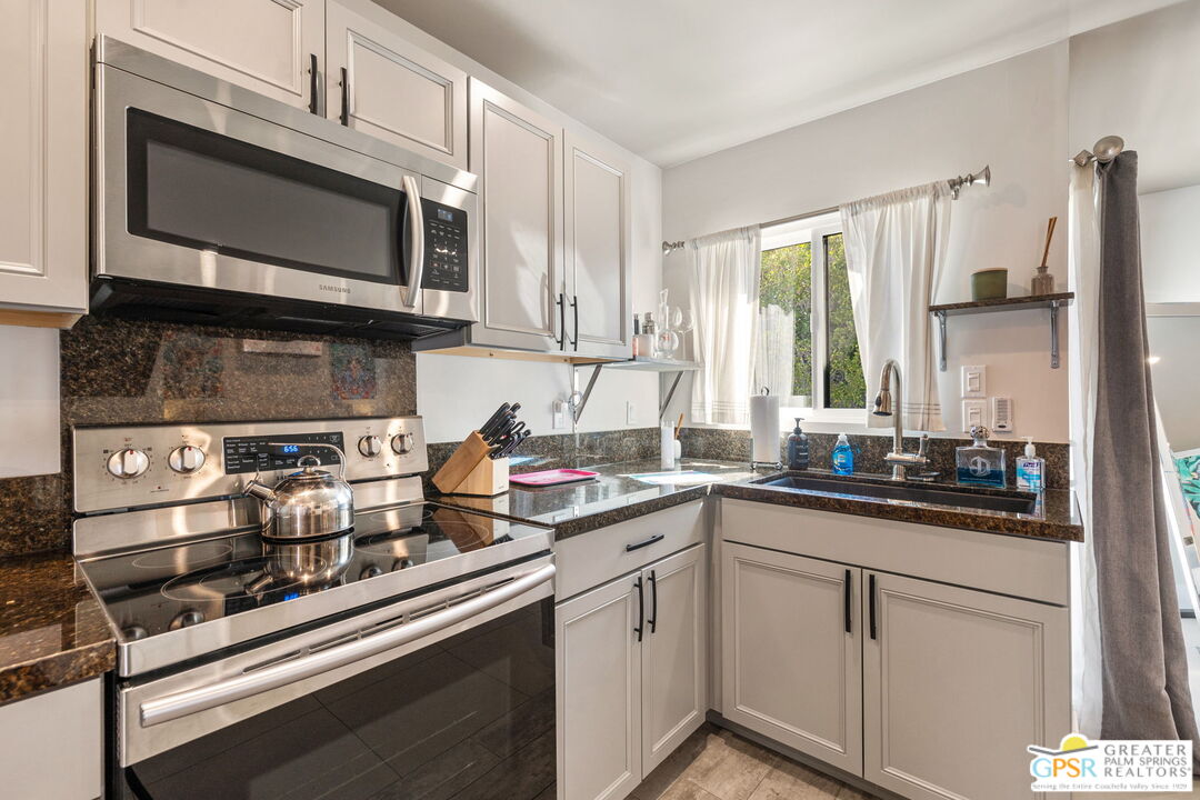 48365 Alan Circle Palm Desert, CA 92260 - Photo 69 of 75 a kitchen with stainless steel appliances granite countertop a sink stove and microwave