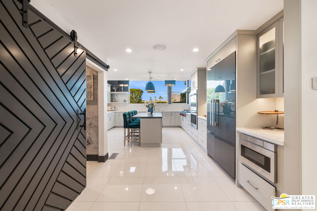 48365 Alan Circle Palm Desert, CA 92260 - Photo 9 of 75 a kitchen with stainless steel appliances kitchen island granite countertop a refrigerator and a sink