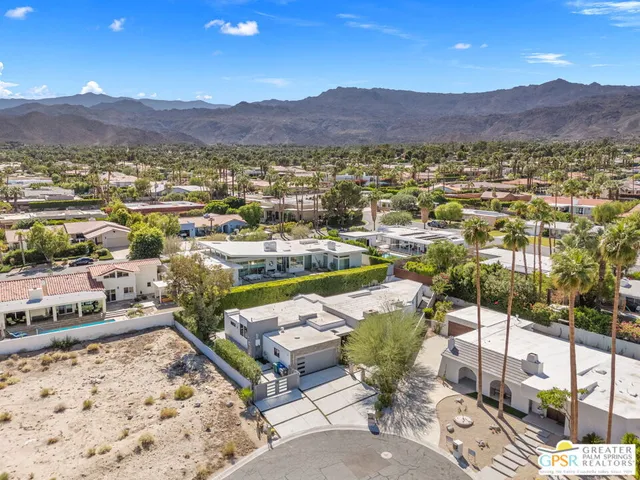 a view of a patio with chairs and a table under an umbrella