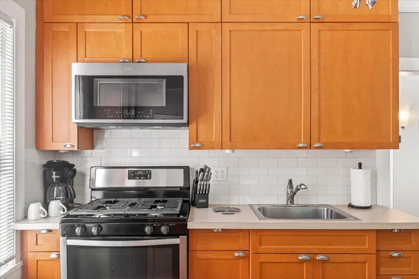a kitchen with stainless steel appliances granite countertop a sink a stove and microwave