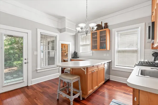 a view of a kitchen area with furniture large windows and wooden floor