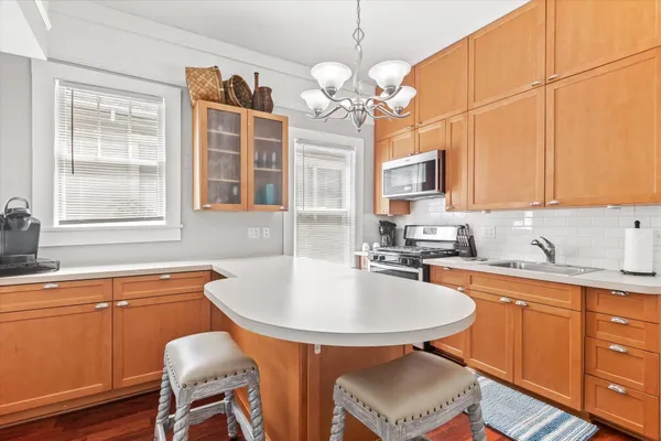a kitchen with a sink chandelier and cabinets