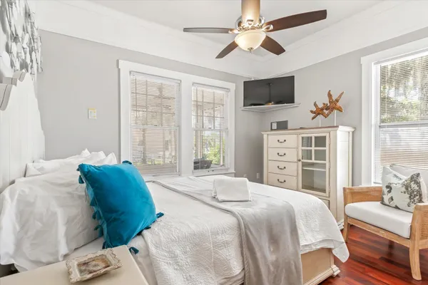 a bedroom with a large bed a flat tv screen and a dresser
