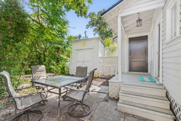 a view of patio with table and chairs and potted plants