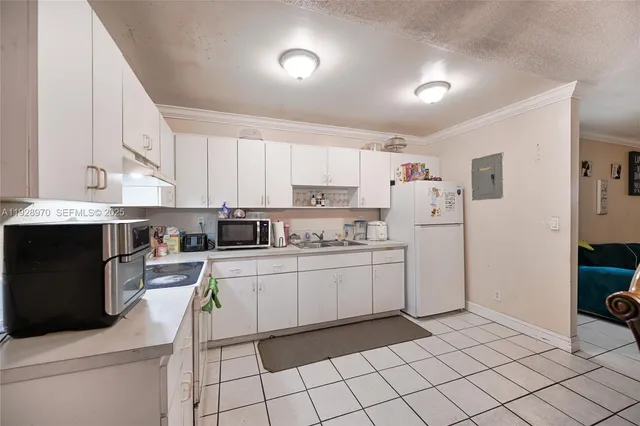 a kitchen with white cabinets and appliances
