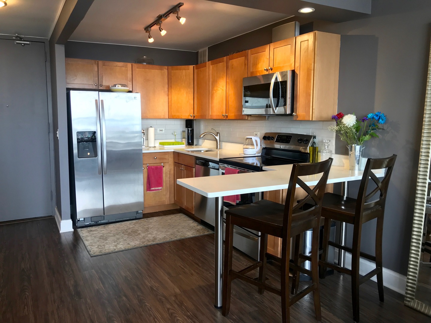 655 West Irving Park Road, Unit 2911 Chicago, IL 60613 - Photo 19 of 42 a kitchen with a table chairs refrigerator and microwave
