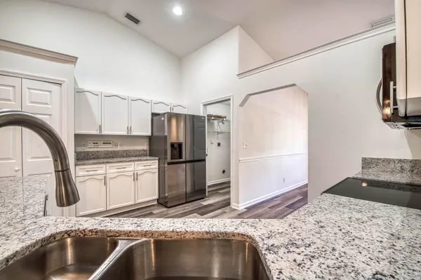 a kitchen with stainless steel appliances granite countertop a sink refrigerator and microwave