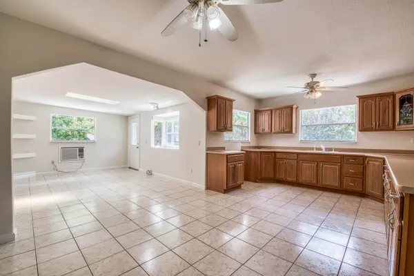 a large white kitchen with a stove a sink dishwasher and a refrigerator
