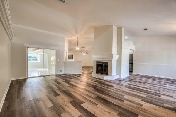 a view of a livingroom with wooden floor and a fireplace