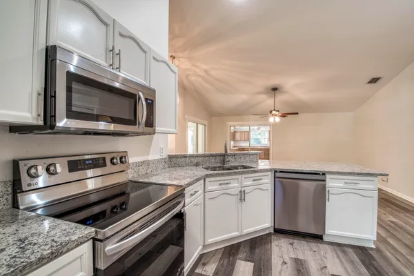 a kitchen with stainless steel appliances kitchen island granite countertop a stove microwave and sink