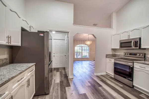a kitchen with granite countertop a stove and a refrigerator