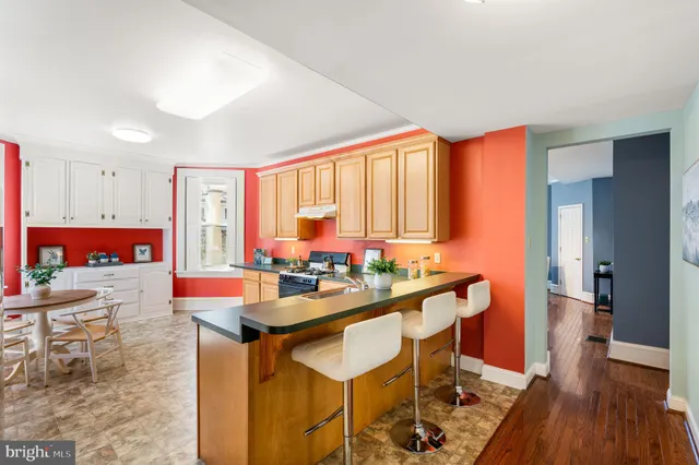 a room with stainless steel appliances kitchen island granite countertop furniture and a wooden floor