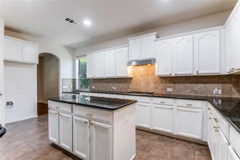 a kitchen with granite countertop white cabinets and white appliances