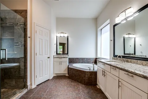a spacious bathroom with a granite countertop tub sink and mirror