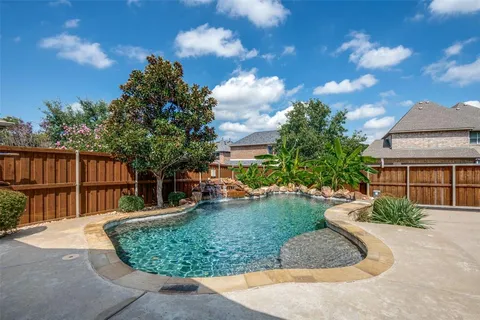 a view of a backyard with plants and outdoor seating