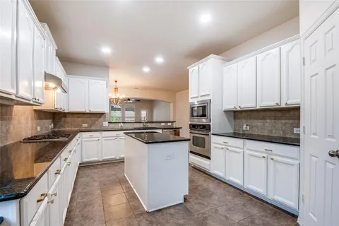 a kitchen with stainless steel appliances kitchen island granite countertop a sink and cabinets