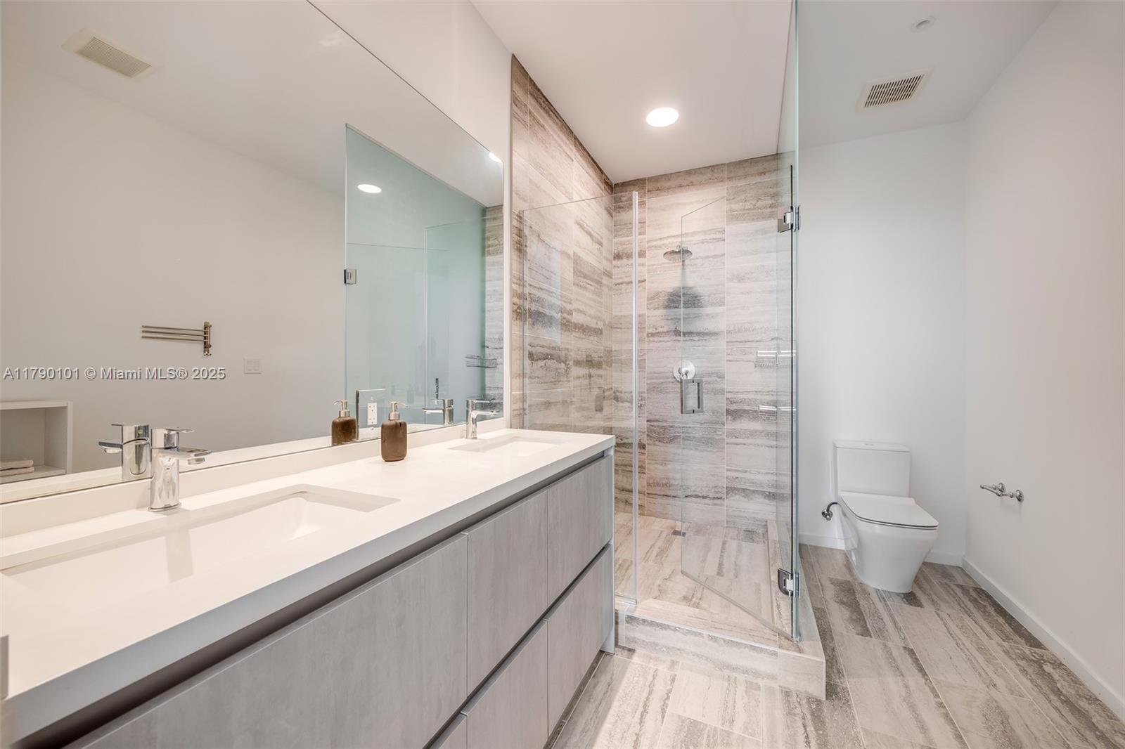 3156 Southwest 27th Avenue, Unit 402 Miami, FL 33133 - Photo 5 of 28 a bathroom with a sink a toilet and shower