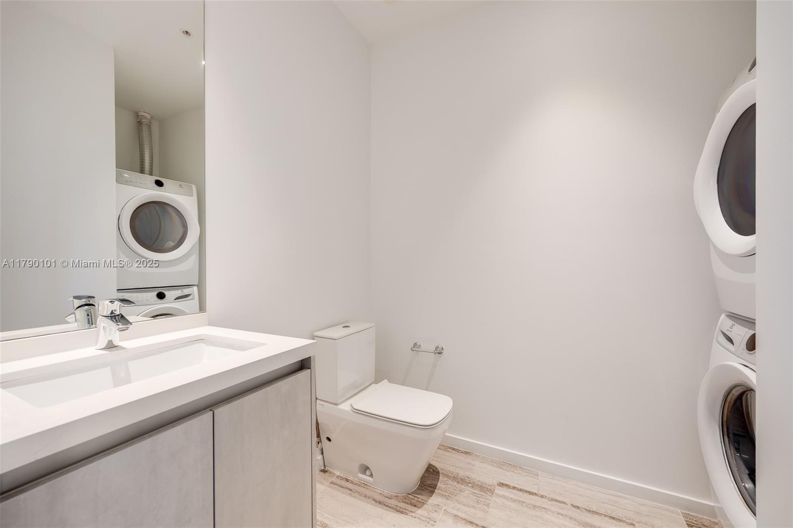 3156 Southwest 27th Avenue, Unit 402 Miami, FL 33133 - Photo 7 of 28 a bathroom with a toilet sink and mirror