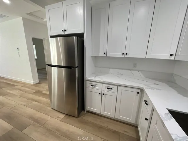 a kitchen with a refrigerator sink and cabinets