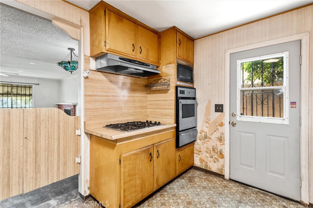 450 West Cromwell Street Rialto, CA 92376 - Photo 13 of 35 Built in oven and microwave. Door leading to West side of the home.