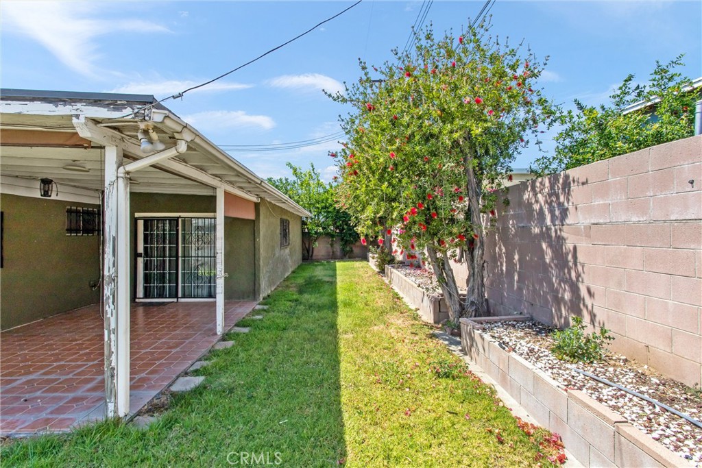 450 West Cromwell Street Rialto, CA 92376 - Photo 31 of 35 Back yard showing raised planter beds, fruit trees, covered tiled patio with roll down shades. Rain gutters on back and front of the home. Nice block wall on both sides of the home and the back of the yard.
