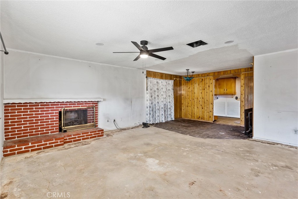 450 West Cromwell Street Rialto, CA 92376 - Photo 8 of 35 Original Image -1. Living room with recessed lighting, ceiling fan, gas/wood bricked fireplace with dining area near the kitchen. With a little TLC (Flooring and paint) this will look fabulous.