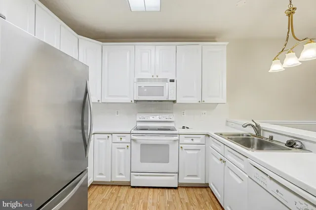 a kitchen with white cabinets and white appliances