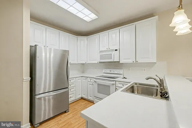 a kitchen with a refrigerator sink and cabinets