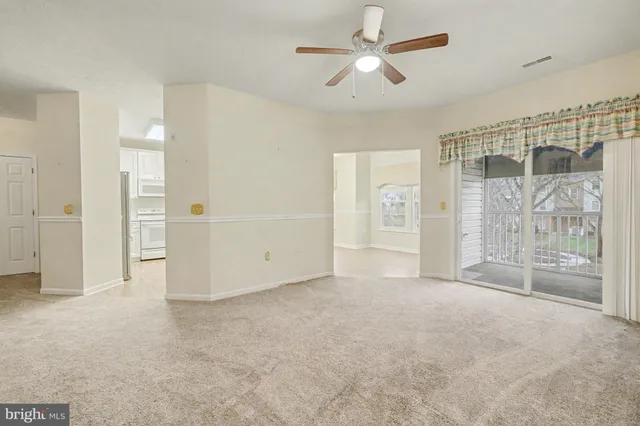 an empty room with fan and entrance door