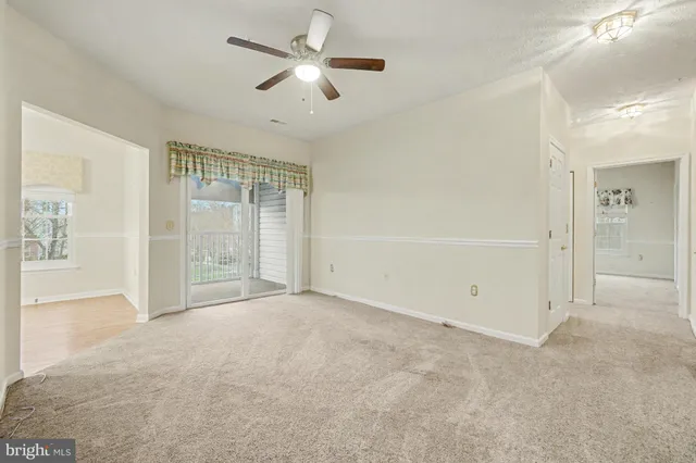 an empty room with fan and windows